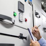Engineer inspecting control panel for UPS system maintenance