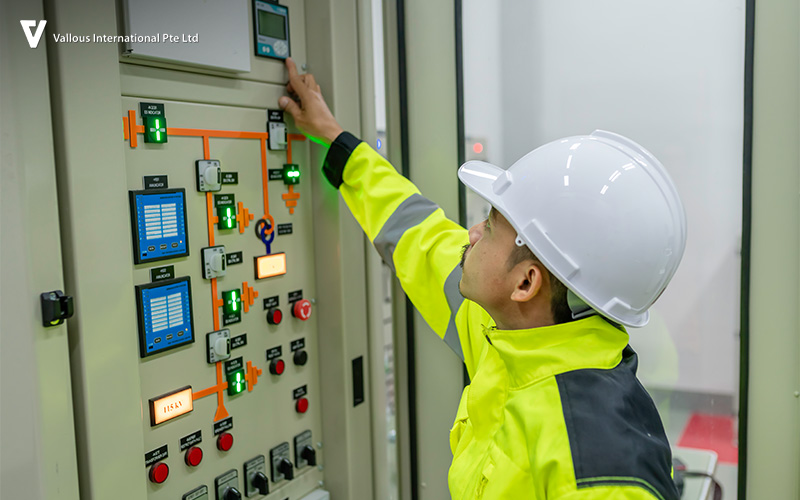 Technician adjusting settings on industrial electrical switchboard